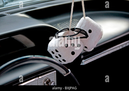 Decorative cotton dice hanging on the rear view mirror of 1950 s car