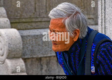 Expressive older Asian woman with head of gray hair Stock Photo