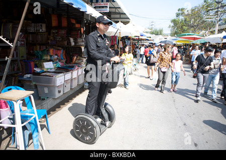 Policeman patrols the Chatuchak Weekend Market on a Segway Stock Photo