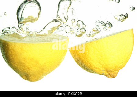 Splash of yellow lemon to water with bubbles of air Stock Photo
