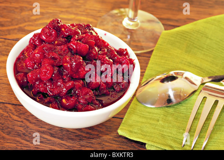 Bowl of fresh cranberry sauce on oak dining table Stock Photo