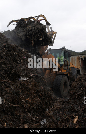 Front loader on compost heap at recycling centre Stock Photo