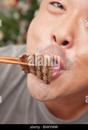 A man eating korean barbecue Stock Photo