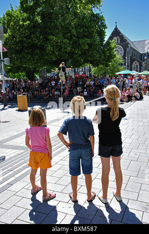 Children watching unicycle street entertainer, Cathedral Square, Christchurch, Canterbury, South Island, New Zealand Stock Photo