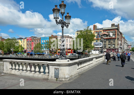 Cast Iron lamp stand on O'Connell Bridge spanning River Liffey in Dublin Ireland and view towards Bachelors walk across river Stock Photo