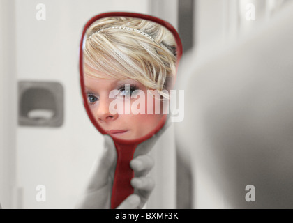 selective coloring bride reflected in mirror preparing for ceremony Stock Photo