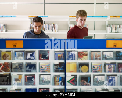 two caucasian people choosing cd in music shop. Horizontal shape, front view, head and shoulders, focus on background Stock Photo