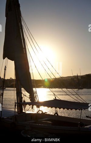 Feluke on Nile river in Aswan city, Egypt at the sunset Stock Photo