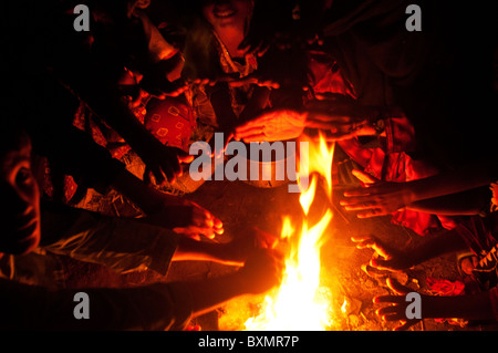 Sindh province. Railway camp for displaced people. People without tents warm themselves by a fire. Stock Photo