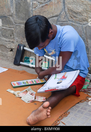 handicapped man drawing pictures to earn a living in Kathmandu, Nepal Stock Photo