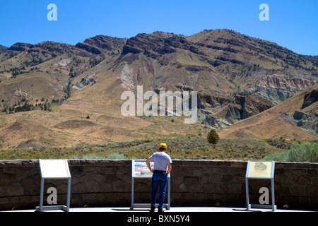 Tourist at the Condon Visitor Center overlooking Sheep Rock at the John Day Fossil Beds National Monument in Eastern Oregon, USA Stock Photo