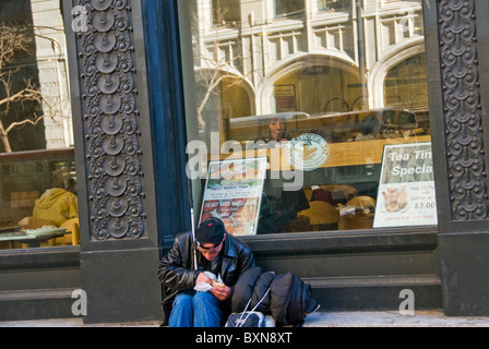 Young blind homeless person eating take out food on city street in San Francisco CA USA California Stock Photo