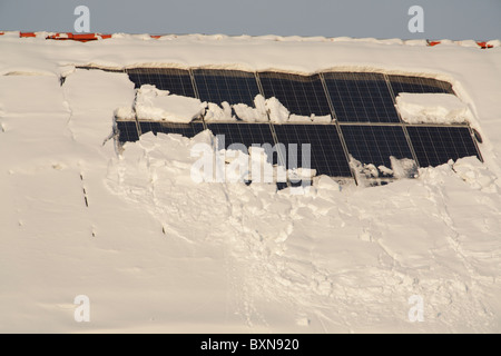 snow covered solar panels on a roof Stock Photo
