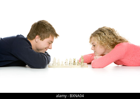 Attractive teenagers lying down playing chess Stock Photo