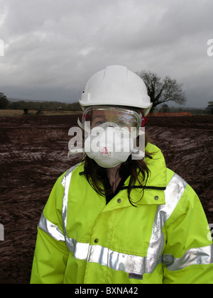 Young lady civil engineer wearing full protective equipment against lime on UK construction site. Stock Photo