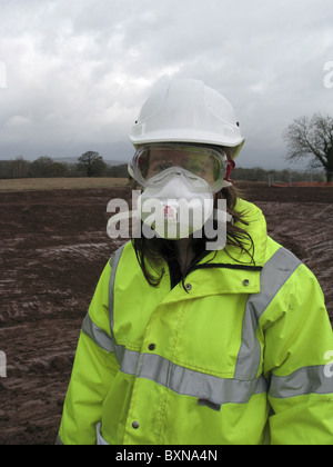 Young lady civil engineer wearing full protective equipment against lime on UK construction site. Stock Photo