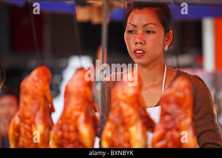Chinese woman selling roasted duck in Yuanyang, Yunnan Province, China Stock Photo