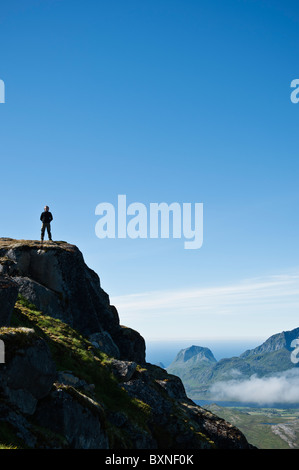 Hiker enjoys view from summit of Justadtind, Lofoten islands, Norway Stock Photo