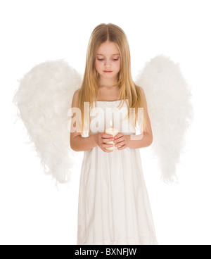 Portrait of white angel holding burning candle and looking at it over light background Stock Photo