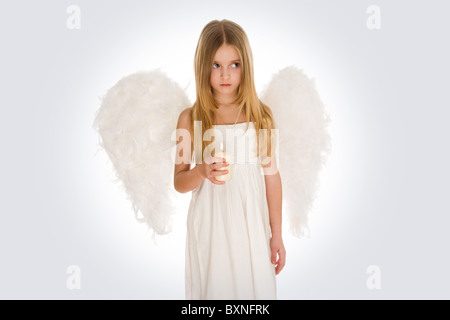 Portrait of innocent angel with burning candle looking aside Stock Photo