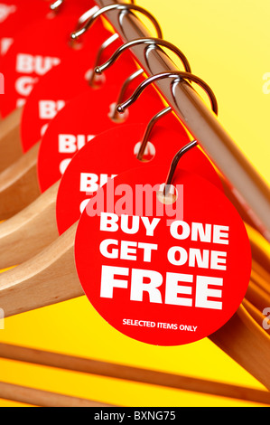 Row of wooden coathangers with Buy One Get One Free tags Stock Photo