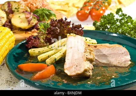 Baked tenderloin with baby corn, lettuce and tomato Stock Photo