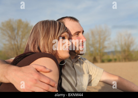 young Caucasian couple close-up sitting on beach outdoors Stock Photo