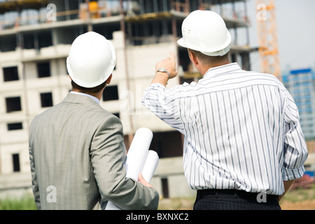 Portrait of boss pointing at construction with worker near by Stock Photo