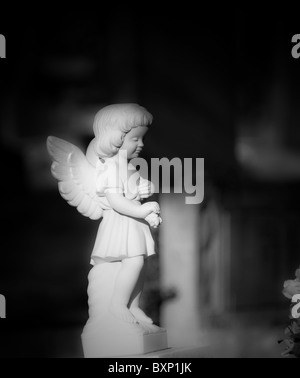 Weathered marble Graveyard Monument of a young angel. Stock Photo