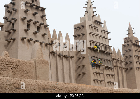 Workers of the 'Aga Khan Trust for Culture' repairing the plasterwork of the Great  Mosque of Djenné, Mali Stock Photo