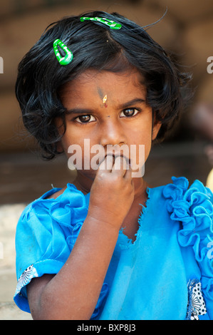 Indian village girl eating wearing a blue dress. Andhra Pradesh, India Stock Photo
