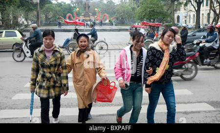 people walking over the road in Hanoi Stock Photo