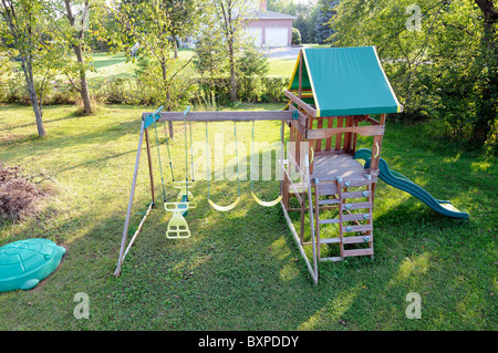 Children's Play Structure With Swings In The Garden Of A House Stock Photo