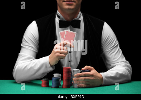 Man with bow tie holding cards and gambling chips Stock Photo