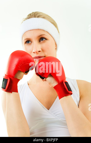 Photo of sporty blond wearing red boxing gloves and white tank-top looking aside Stock Photo