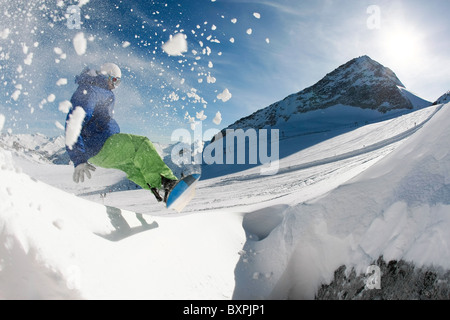 Photo of snowboarder over snowdrift going in for sport in winter Stock Photo