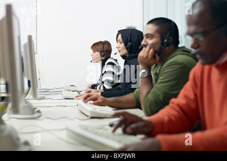 Multiethnic computer class with indian, middle eastern, hispanic and caucasian people training with pc. Stock Photo