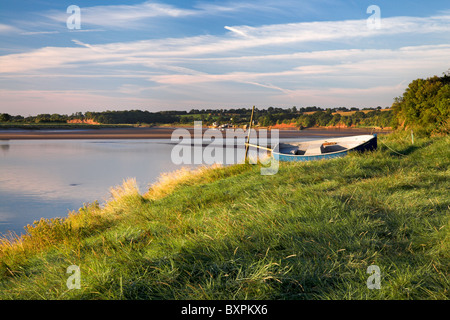 A small boat on the grassy bank of the river Severn at Newnham-on-Severn, Gloucestershire. Stock Photo