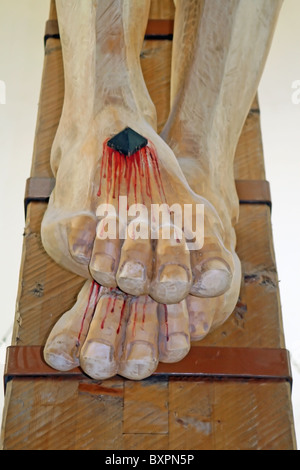 nailed and bleeding feet of Jesus Christ crucified in a church Stock Photo