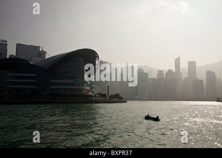 Hong Kong Island China city skyline of Central District and Victoria Harbour from Kowloon, small fishing boat in sea Stock Photo