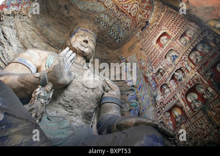 Statue And Carvings In Ancient Buddhist Temple Grotto. Stock Photo