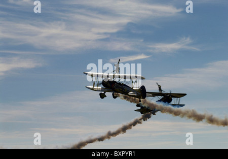 Two stunt biplanes with two wing-walking stunt performers (both girls) at an airshow. Stock Photo