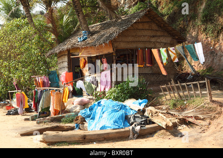 A small tailor's shop on Varkala beach, Kerala, offers hand-made cotton goods for passing locals and tourists. Stock Photo