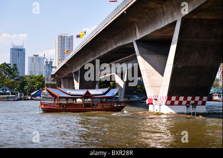 The Chao Phraya river is the royal river cutting through Bangkok and full of different types of boats and other river transport. Stock Photo