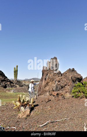 Woman viewing rough shaped lava formations in El Pinacate Biosphere Reserve, Sonora, Mexico Stock Photo