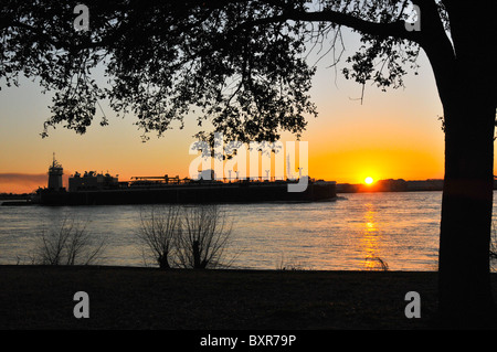 Sunset on Mississippi with tug and barge, New Orleans, Louisiana Stock Photo