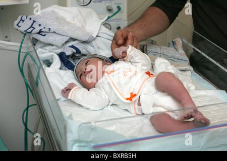 Father holding the hand of newborn baby boy right after birth. Stock Photo