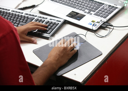Man using keyboard, mouse and laptop. Stock Photo