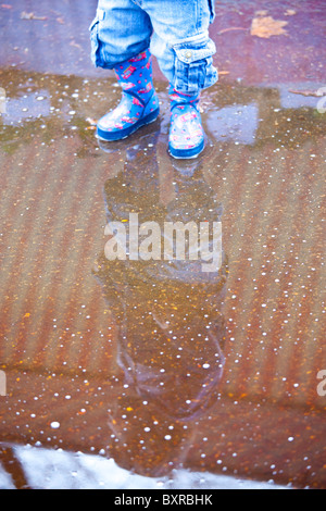 Small child splashing in a puddle in Washington DC Stock Photo