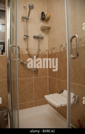 A disabled shower cubicle complete with chair and support handle bar in